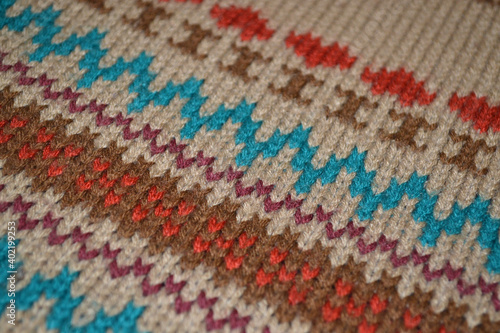 Pattern on a knitted beige jacket with a letter, hearts and zigzags