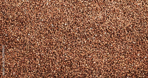 Background and texture of dry brown buckwheat. View from above.	