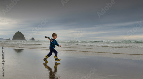 Boy throws driftwood into the ocean
