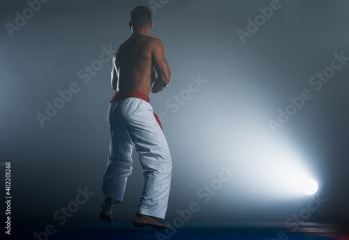 One karate kata training man isolated on dark background © qunica.com
