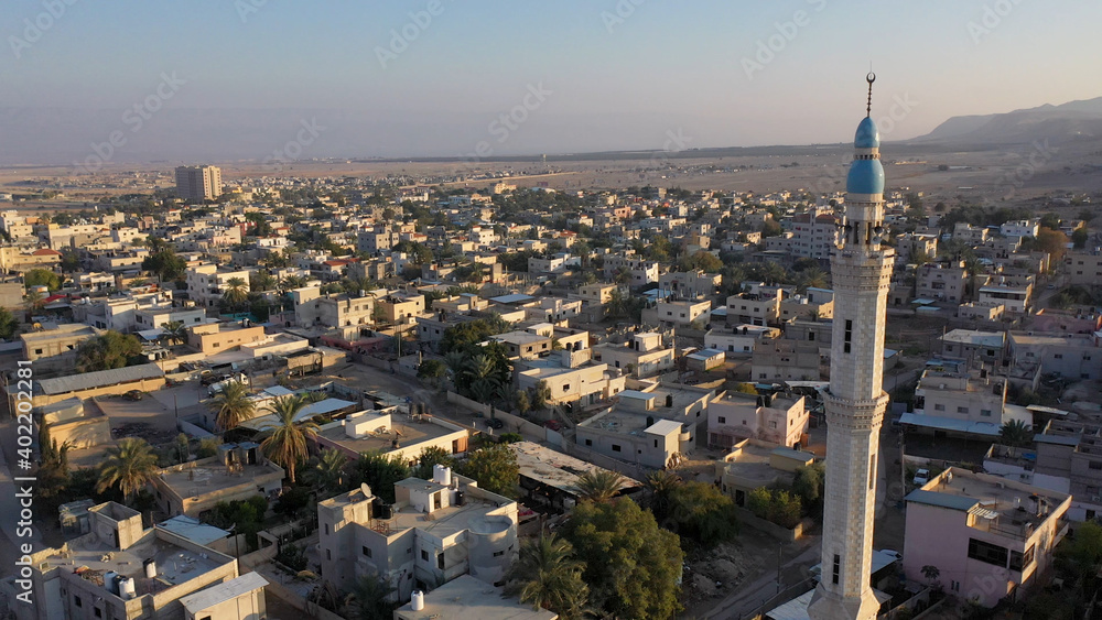Fototapeta premium Mosque Tower minaret in Jericho city with Birds- aerial view Drone view of Jericho city,sunset, Jordan Valley, Israel/palestine 