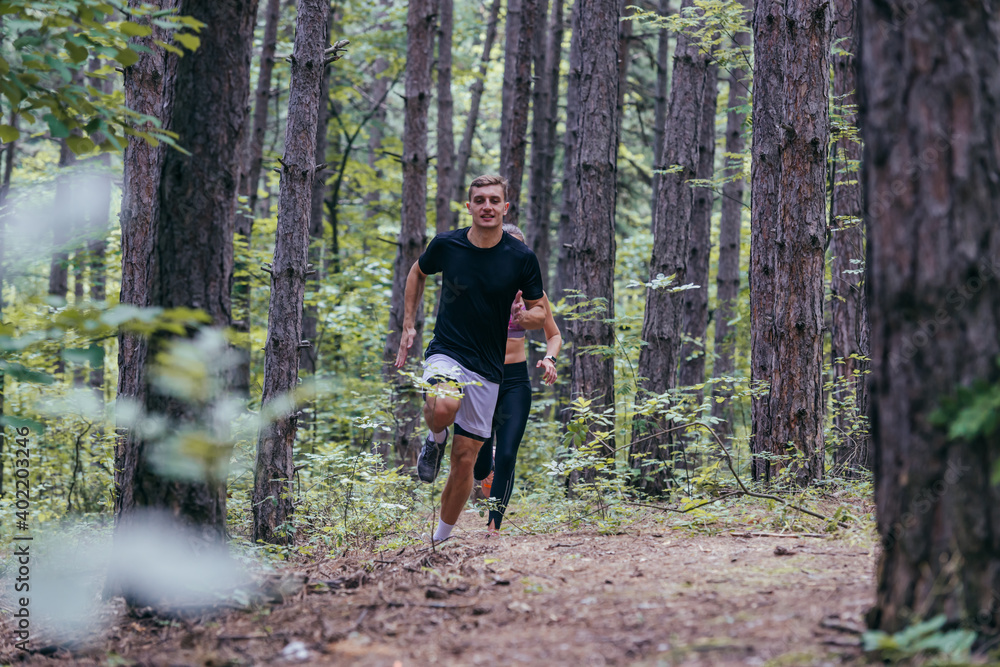 Obraz premium Strong male runner jogging for marathon on forest road