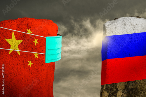 Bilde på lerret Two mountains russia and china stand together with the china mountain wearing a mask protecting from coronavirus virus at sunset cloudy day