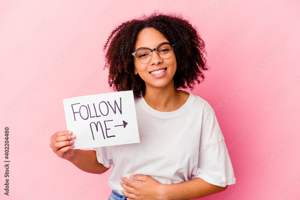 Young african american mixed race woman holding a follow me concept laughing and having fun. Young african american mixed race woman holding a follow me concept laughing and having fun.