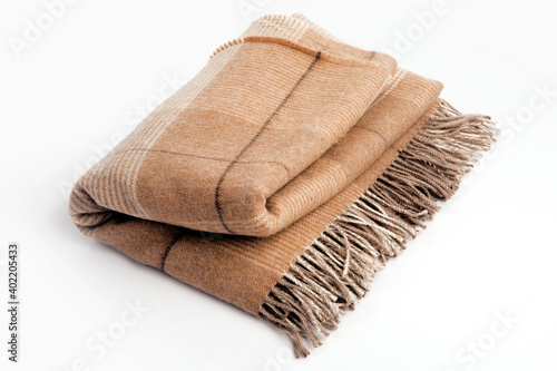 Warm brown alpaca wool or cashmere blanket isolated on white background. Beige, brown squared wool fabric for house design.