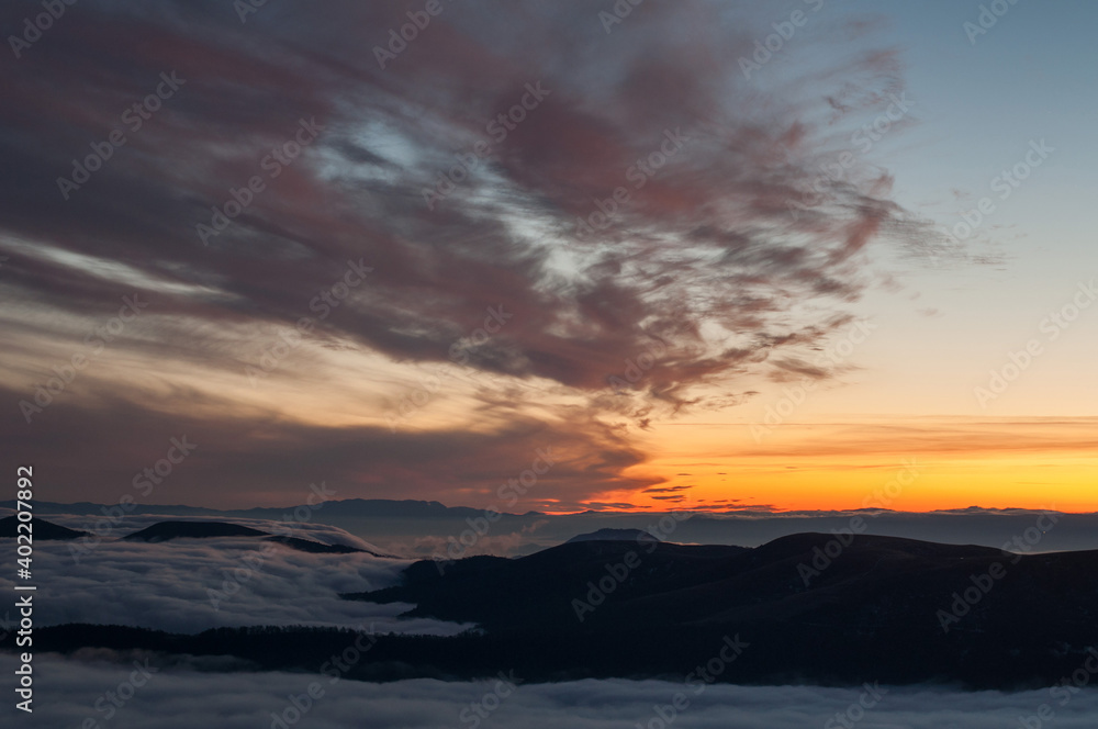 Magical sunset somewhere in Carpathian mountains. Magic warm light. At the top of a hill. Sunset over the mountains. 