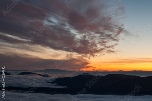 Magical sunset somewhere in Carpathian mountains. Magic warm light. At the top of a hill. Sunset over the mountains. 