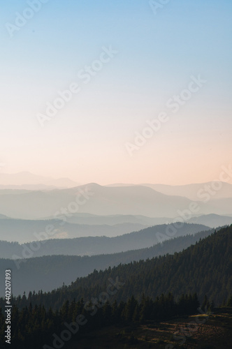 Carpathian mountains. Sunbeams thru forest. Mountain silhoettes. Ridgeline
