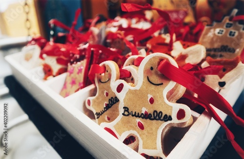 Gingerbread man cookies being sold in a Christmas market in Brussels, Belgium. Happy, bright, festive photo of ginger cookies decorated in white frosting, with red ribbon to hang on a tree