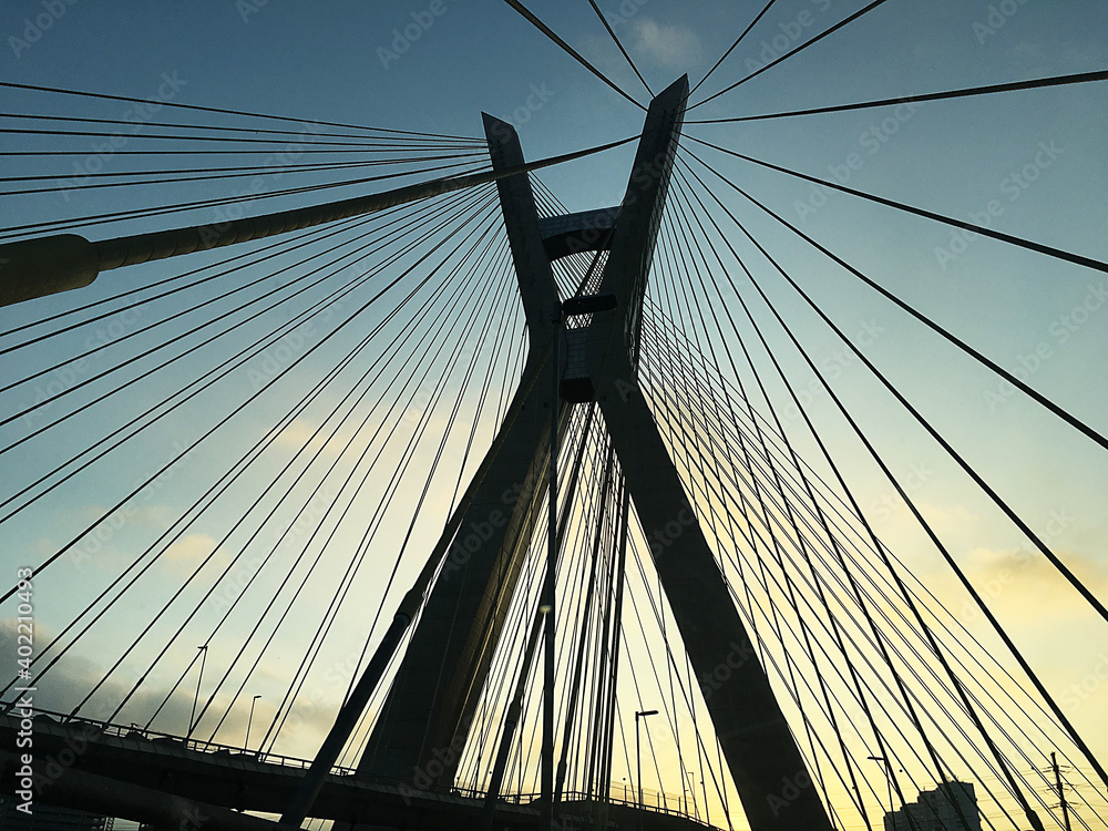 Fototapeta premium SÃO PAULO, BRAZIL - SEP 02, 2020 Crossing the cable-stayed bridge in são paulo during the quarantine period. Passing through intense traffic and with the sunset. Bridge concept. Traffic concept.