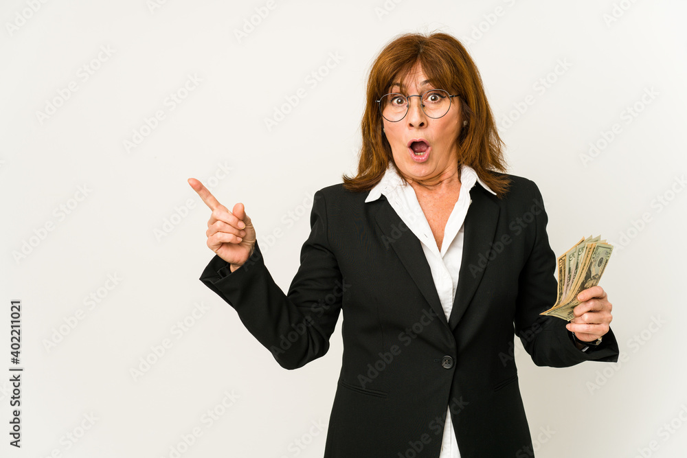 Middle age caucasian business woman holding banknotes isolated pointing to the side Middle age caucasian business woman holding banknotes isolated pointing to the side