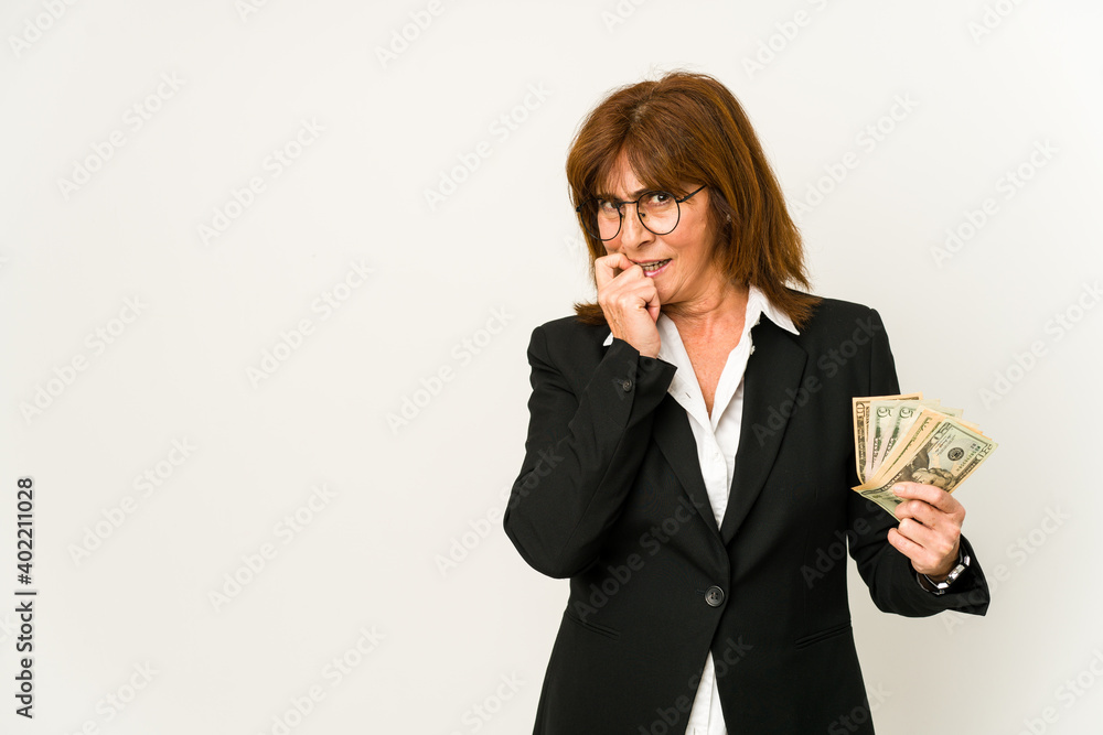 Middle age caucasian business woman holding banknotes isolated relaxed thinking about something looking at a copy space. Middle age caucasian business woman holding banknotes isolated relaxed thinking about something looking at a copy space.