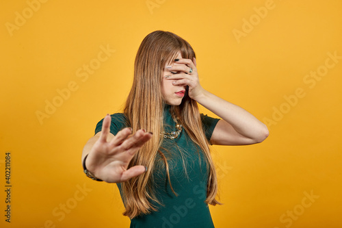 Palm arm raised air angry look straight you will not pass through facial expression harsh. Serious looking strict demands stop, pulls hand forward camera, says no, disagrees, frowns face, warning