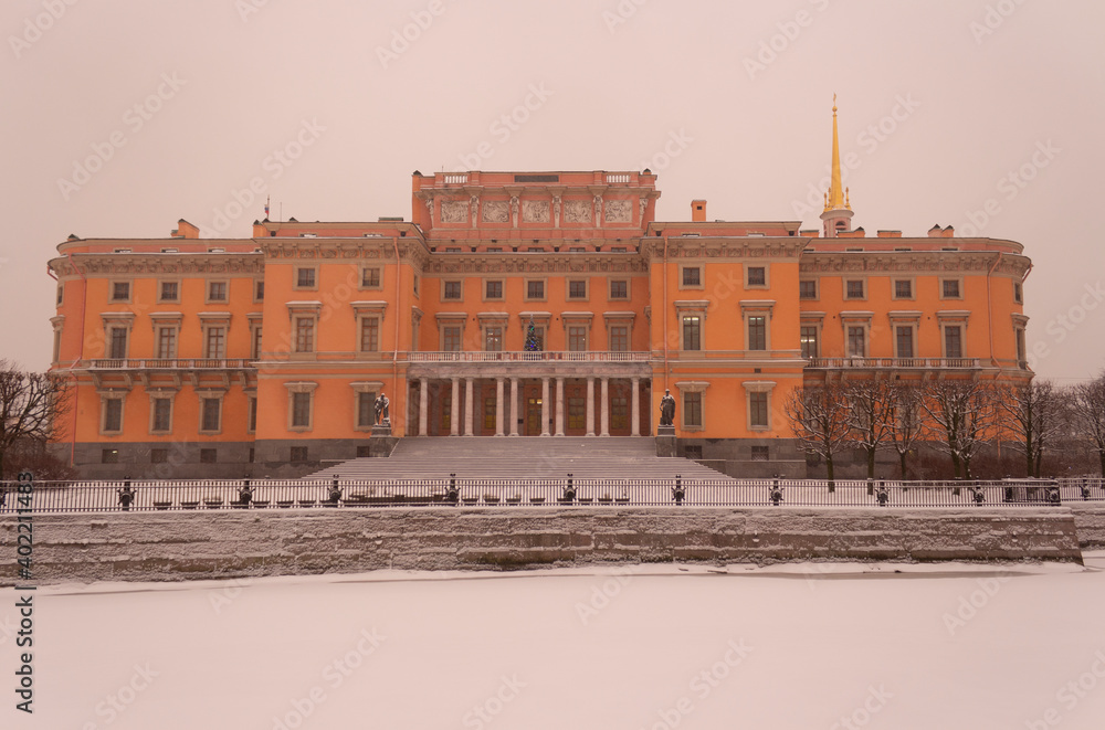 Snow-covered Moika river and a view of the Mikhailovsky Palace in St. Petersburg, a snowy and traditionally gloomy day in December. Winter in St. Petersburg in Russia