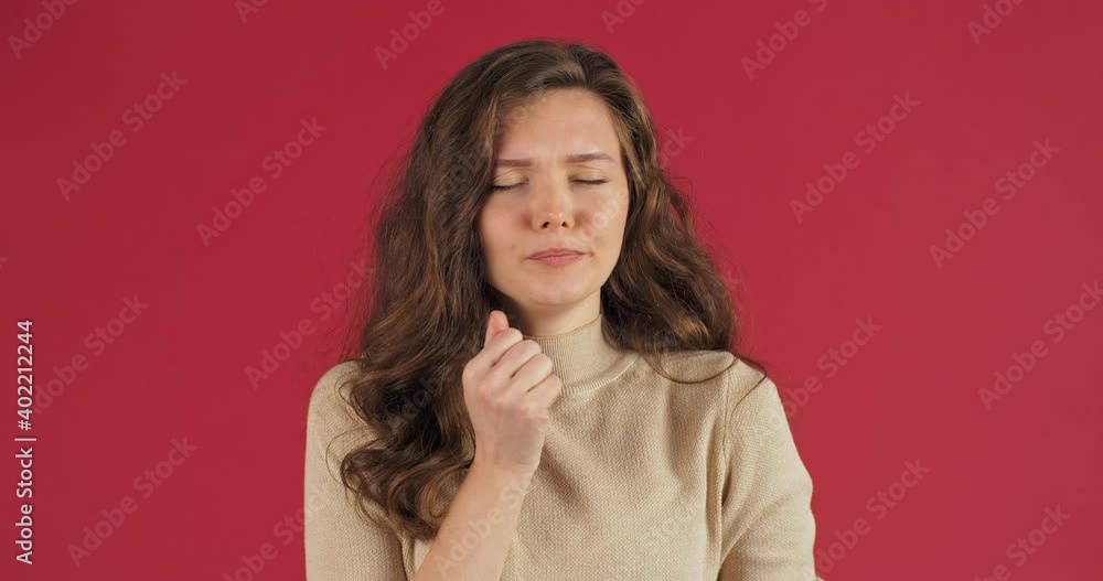 Portrait of caucasian sleepy woman with long hair in beige sweater on red background yawns opens her mouth covering it with his palm feels overwhelmed stress pressure suffers from insomnia tension Portrait of caucasian sleepy woman with long hair in beige sweater on red background yawns opens her mouth covering it with his palm feels overwhelmed stress pressure suffers from insomnia tension