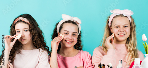 Creative. friendship and sisterhood. family bonding time. childhood happiness. retro kids put on makeup. skin care cosmetics for children. beauty and fashion. three happy girls at hairdresser