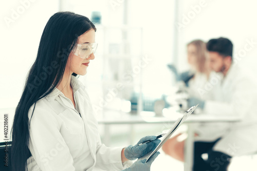 close up. woman scientist reading notes in a laboratory journal