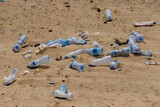 in the desert tossed in the sand a lot of plastic bottles and other waste