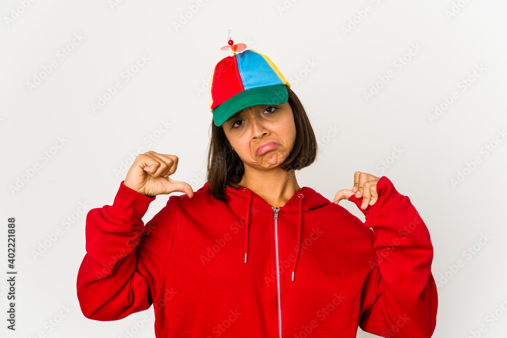Young hispanic woman wearing a cap with propeller isolated feels proud and self confident, example to follow. Young hispanic woman wearing a cap with propeller isolated feels proud and self confident, example to follow.