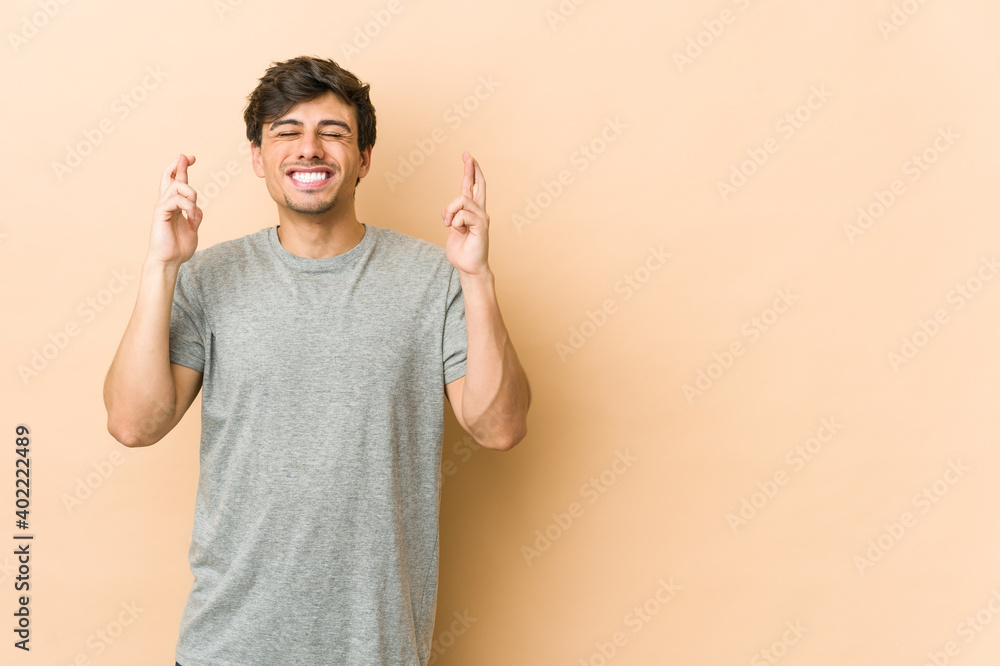 Young cool man crossing fingers for having luck Young cool man crossing fingers for having luck