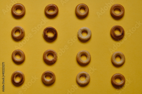 Top view of Sushki pattern on yellow surface. dish of Russian and Ukrainian cuisine, solid ring-shaped product made of dough, type of mutton products. One of the most common tea snacks among Slavs