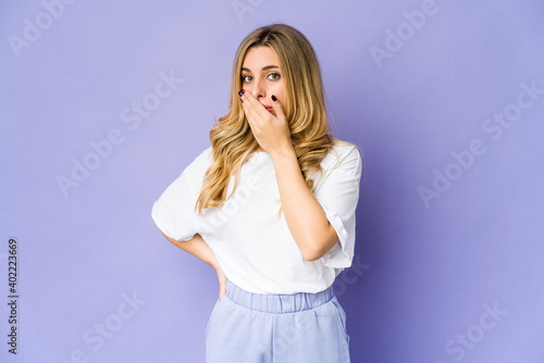 Young caucasian blonde woman covering mouth with hands looking worried.