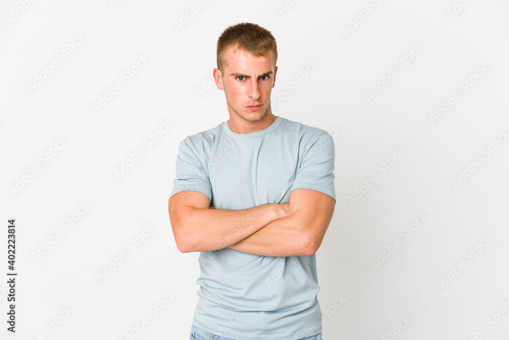 Young caucasian handsome man frowning face in displeasure, keeps arms folded. Young caucasian handsome man frowning face in displeasure, keeps arms folded.