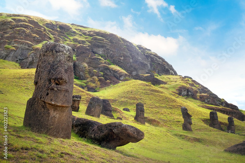 Moai on the slopes of the Rano Raraku Volcano, on Easer Island, against a blue sky covered by white clouds. photo