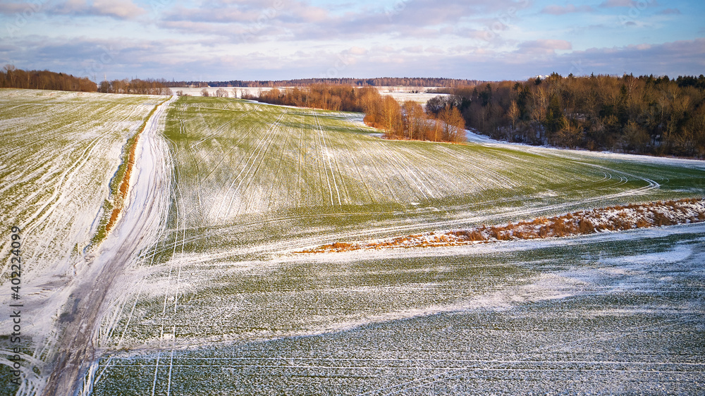 Winter Agricultural field under snow. Aerial scene. December Rural landscape. Countryside road
