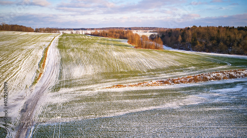 Obraz na płótnie Winter Agricultural field under snow. Aerial scene. December Rural landscape. Countryside road w salonie