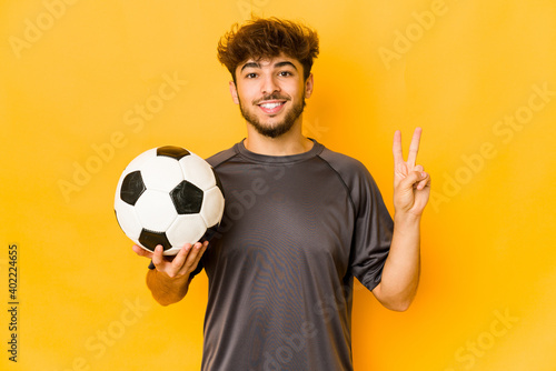 Young soccer player indian man showing number two with fingers.