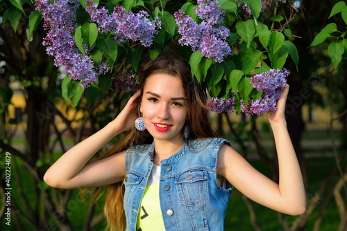 Portrait of a beautiful girl with lilac flowers