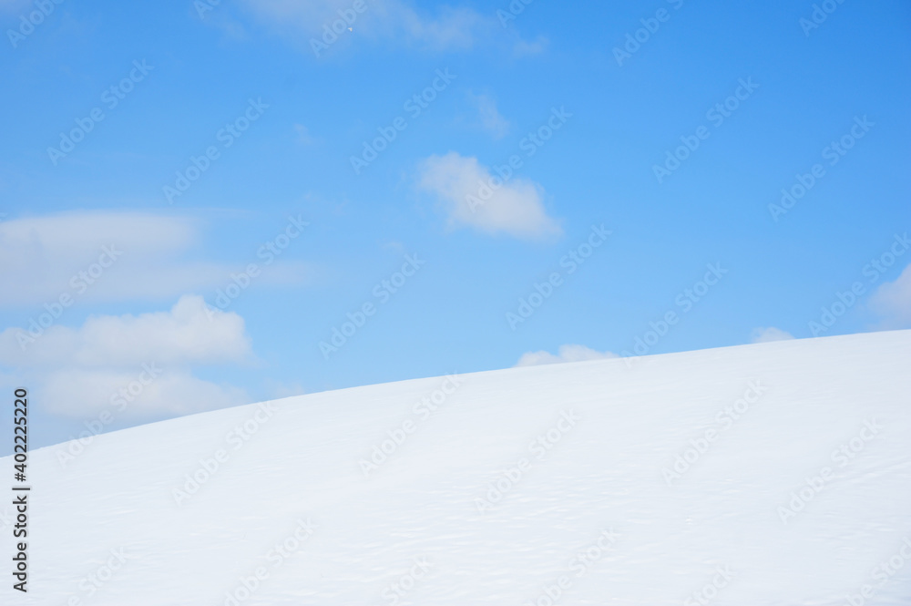 Bright White snow over hillside creates great contrast with deep blue sky and fluffy white clouds wonderful background  in Alberta Canada