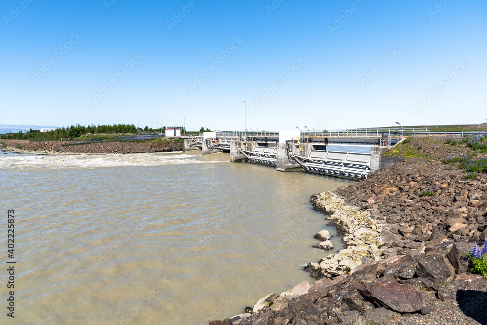 Small dam for electricity generation on a river in Iceland on a clear summer day