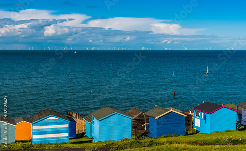 A panorama view across the beach huts at Tankerton out into the Thames Estuary in summer