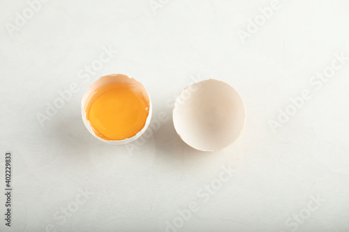 Broken organic egg on white background