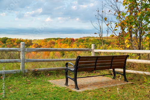 A bench overlooks the changing of the warm autumn colors at Ontario's Rouge Urban National Park.