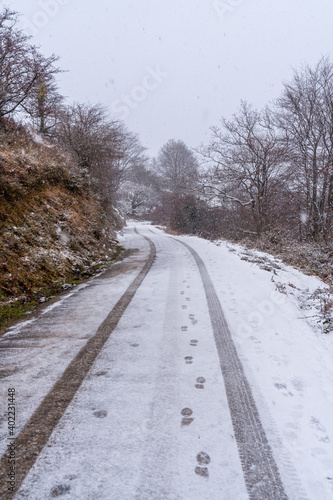 Car tracks on the road to mount aizkorri in gipuzkoa. Snowy landscape by winter snows. Basque Country  Spain