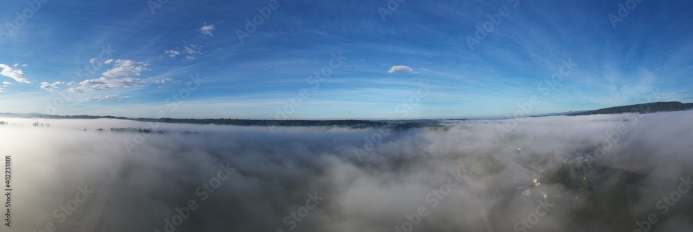 Aerial above fog covering farmland along river