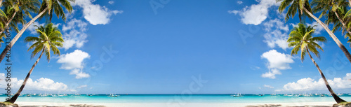 Tropical beach with coconut palm trees, white sand and turquoise sea. Travel concept. Long banner