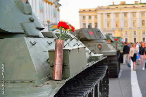 ST.PETERSBURG, RUSSIA - AUGUST 08, 2017: Red carnations in a gun cartridge on a heavy Soviet tank KV-1 on the background of Palace square and the people