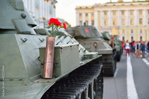 Red carnations in a gun cartridge on a heavy Soviet tank KV-1 on the background of the Palace square