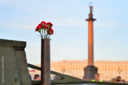 ST.PETERSBURG, RUSSIA - AUGUST 08, 2017: Red carnations in a gun cartridge on a light Soviet tank T-38 on the background of Alexandria post