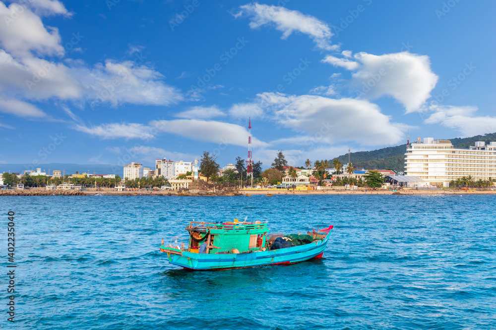Fototapeta premium Vietnamese fishing boat crossing harbor. Local wooden boat in Vietnam