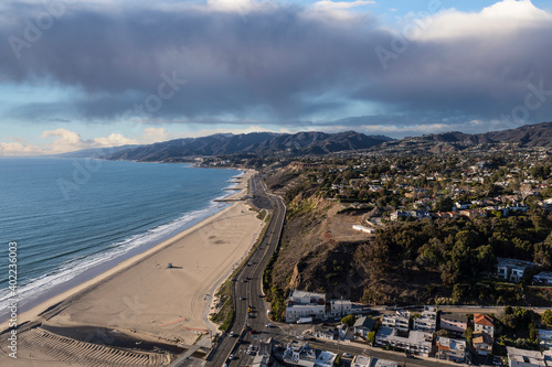 Aerial view of homes, beaches, mountains with stormy sky in the Pacific Palisades area of Los Angeles California.