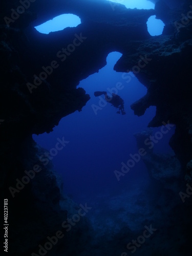 Scuba divers underwater exploring caves blue ocean scenery