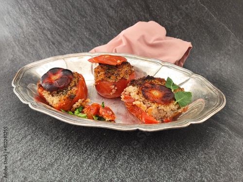Baked tomatoes filled with quinoa in a silver ancien tray