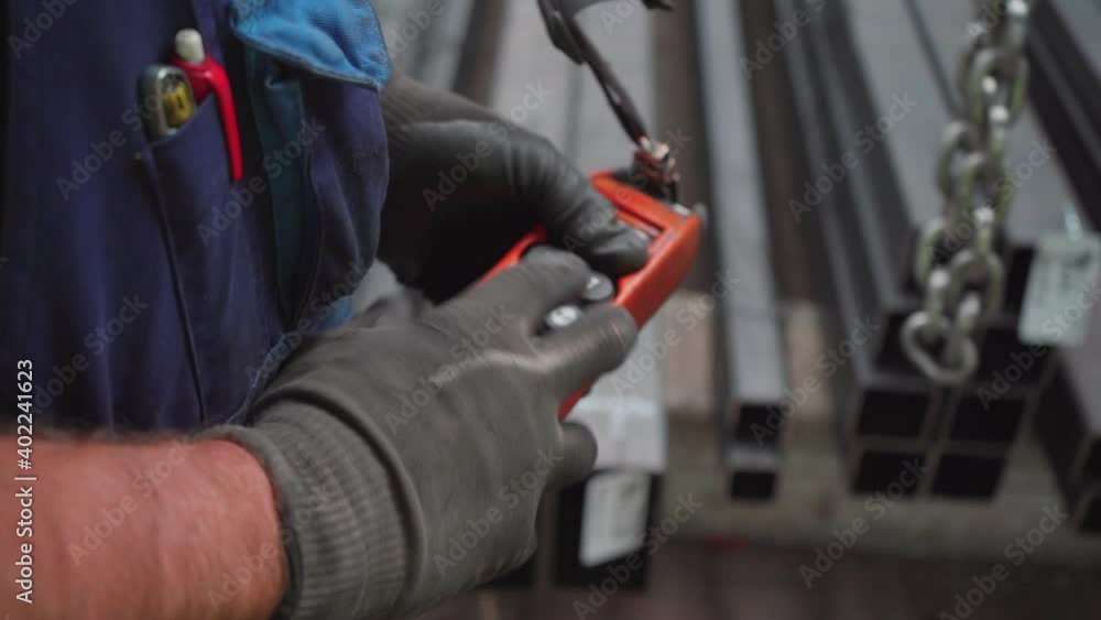 Construction site worker operating crane lifting machinery with controller Construction site worker operating crane lifting machinery with controller