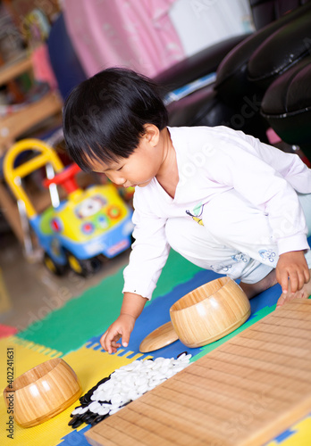 Little girl playing Go chess pieces photo