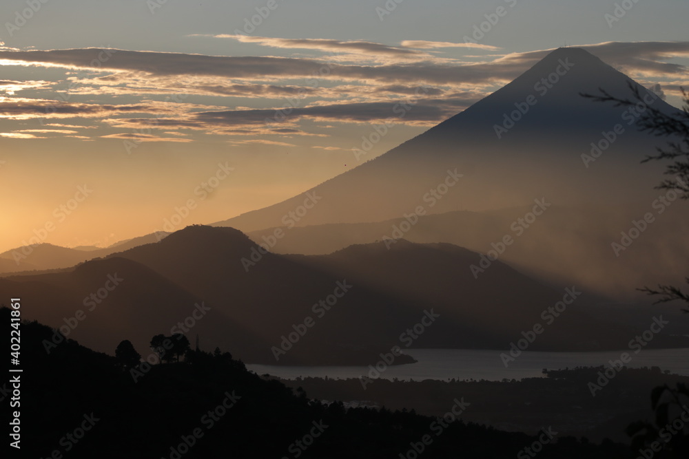 sunset in the mountains with volcano over a lake in Guatemala